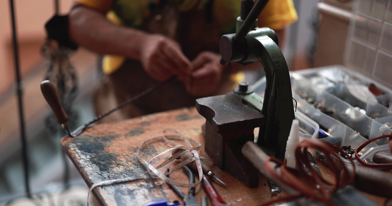 Close-up of Artisan's Hands Crafting on a Workshop Workbench