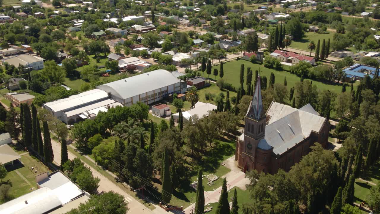 paralaje orbital de iglesia de estilo romántico rodeada de árboles con el pueblito de santa anita al fondo, entre rios, argentina