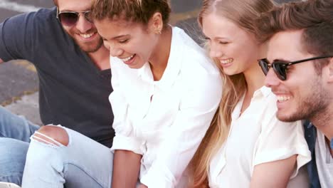 happy hipster friends sitting in the street