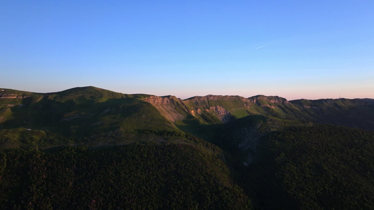 Aerial sunrise over Lake Geneva with fiery orange and red skies, panoramic Alpine views, and tranquil morning reflections on Lac Léman from the Jura.