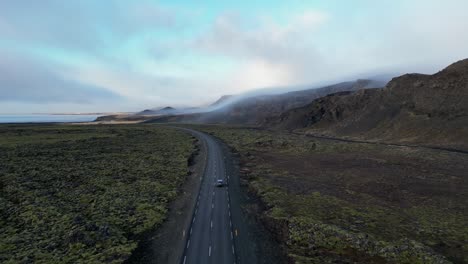 tomada de un avión no tripulado de un coche conduciendo en islandia durante el invierno en un campo de musgo4