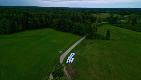 aerial view of a rural landscape with hay bales and a dirt road