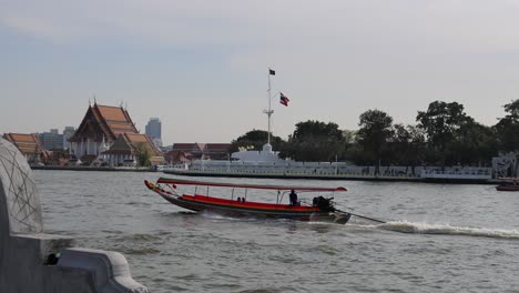 speedboat cruising by traditional temples on riverbank