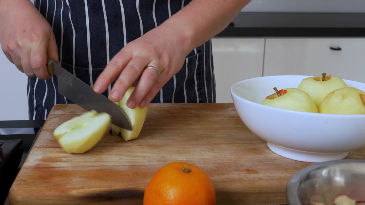 Chef slices cuts apples on a wooden cutting board