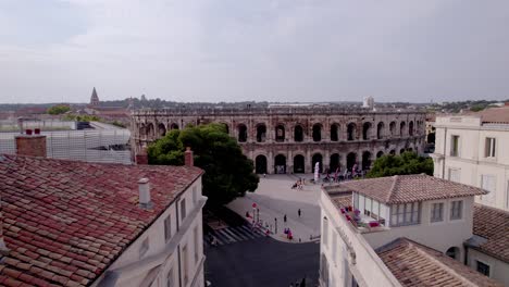 Aerial-view-between-two-buildings,-to-reveal-the-arenas-of-Nîmes,-the-Roman-museum
