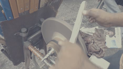 seller sharpening knife using grinder in streets near kr market, india in slow motion