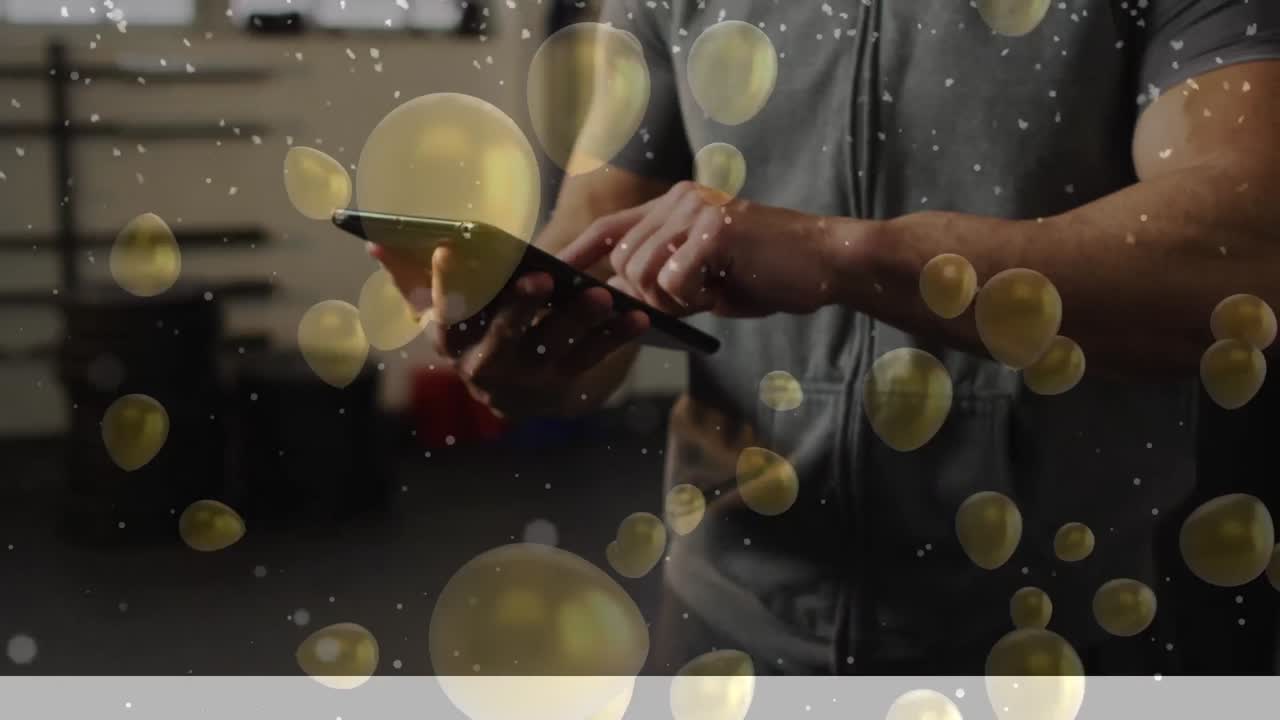 체육관 에서 태블릿 을 사용 하는 백인 남성 운동 선수 위 에 떠다니는 풍선 의 애니메이션