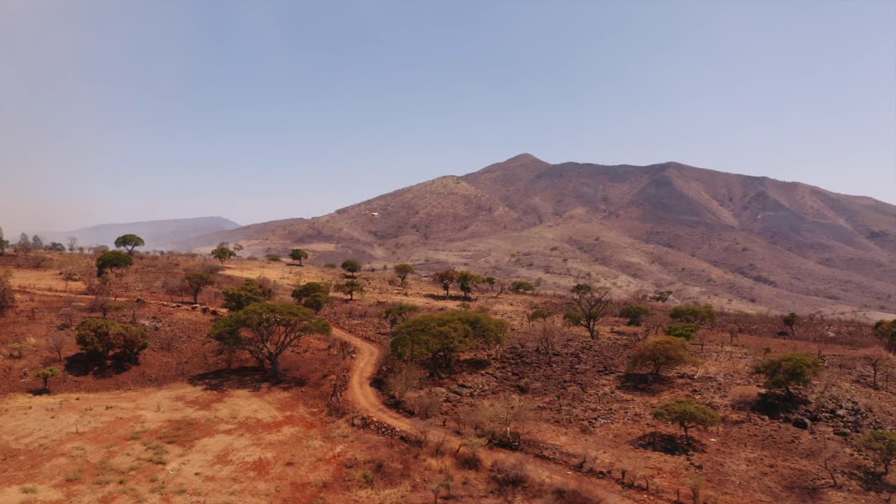 vista aérea helicóptero de respuesta que ayuda con el desastre de incendios forestales de hierba seca en el valle rural de monterrey en la región de la huasteca de méxico