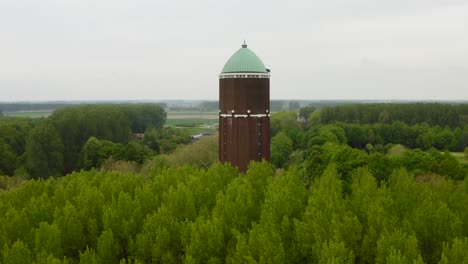 acercamiento aéreo a la famosa torre de agua en la ciudad de axel rodada en un día nublado con muchos árboles rodeados