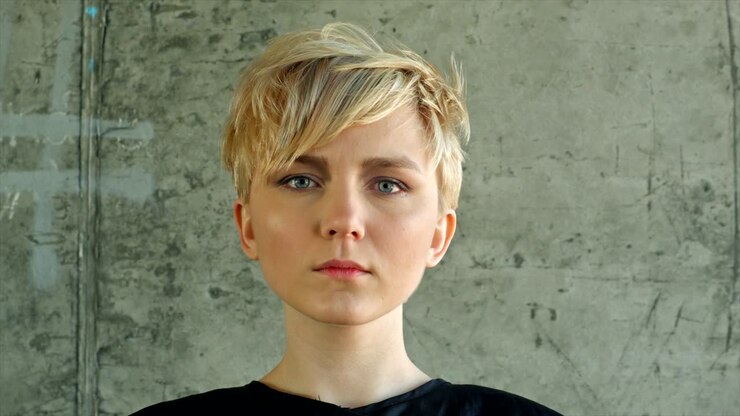Final touch by hairdresser. Blond girl hairdress