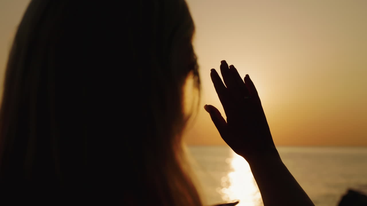 해변에서 해가 지는 것을 즐기는 여자