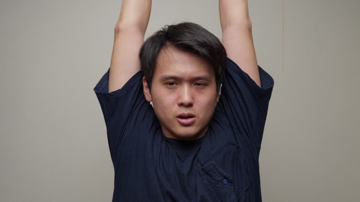Young Asian Man Outstretching His Arms and Stretching Exercises, Portrait Front View