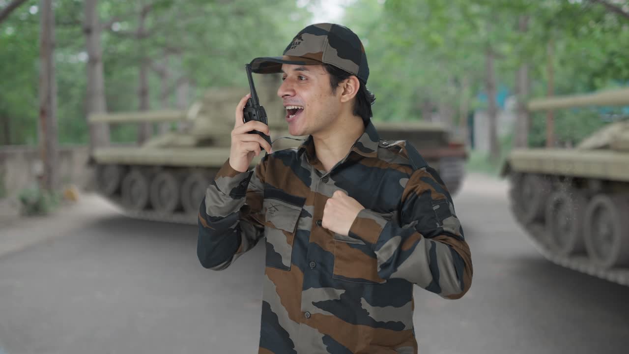 Soldato indiano felice che dà istruzioni al walkie-talkie