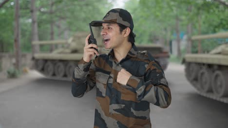 happy indian army man giving instructions on walkie talkie