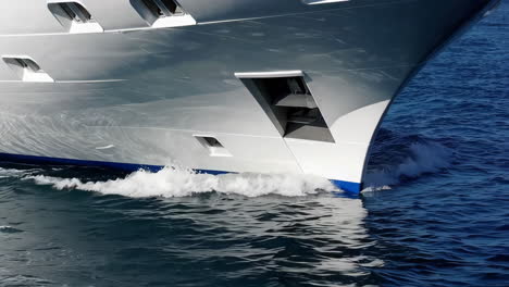 the bow of a large white yacht cruising through blue water