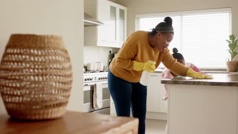 Glückliche-Afroamerikanische-Mutter-Und-Tochter-Putzen-Arbeitsplatte-In-Der-Küche,-Zeitlupe,-Kopierraum