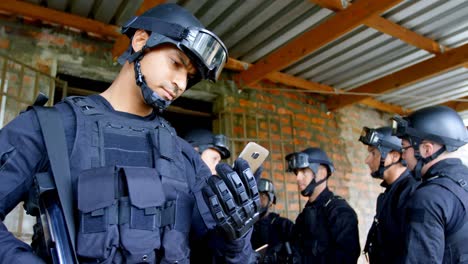 vista frontal de un joven soldado militar caucásico mirando un teléfono móvil en la base militar 4k