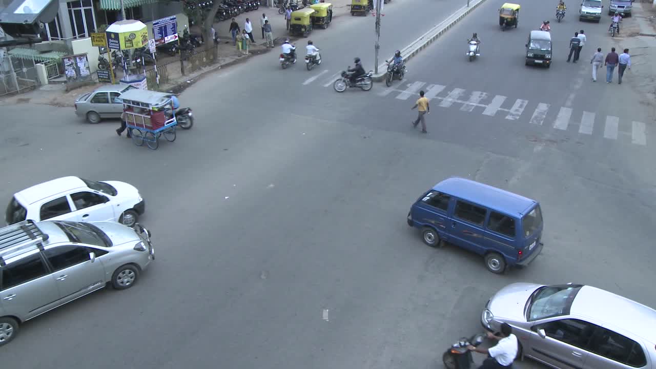 차량과 보행자가 바쁜 교차로를 통과합니다.