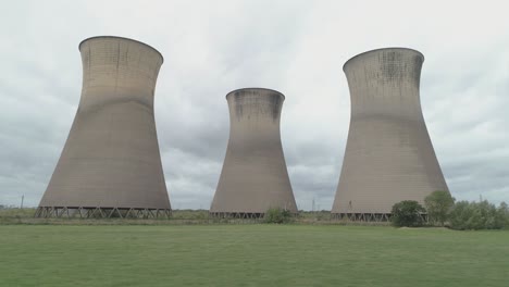 Low,-aerial,-dolly-shot-of-Willington-Power-Station-cooling-towers-on-an-overcast-day