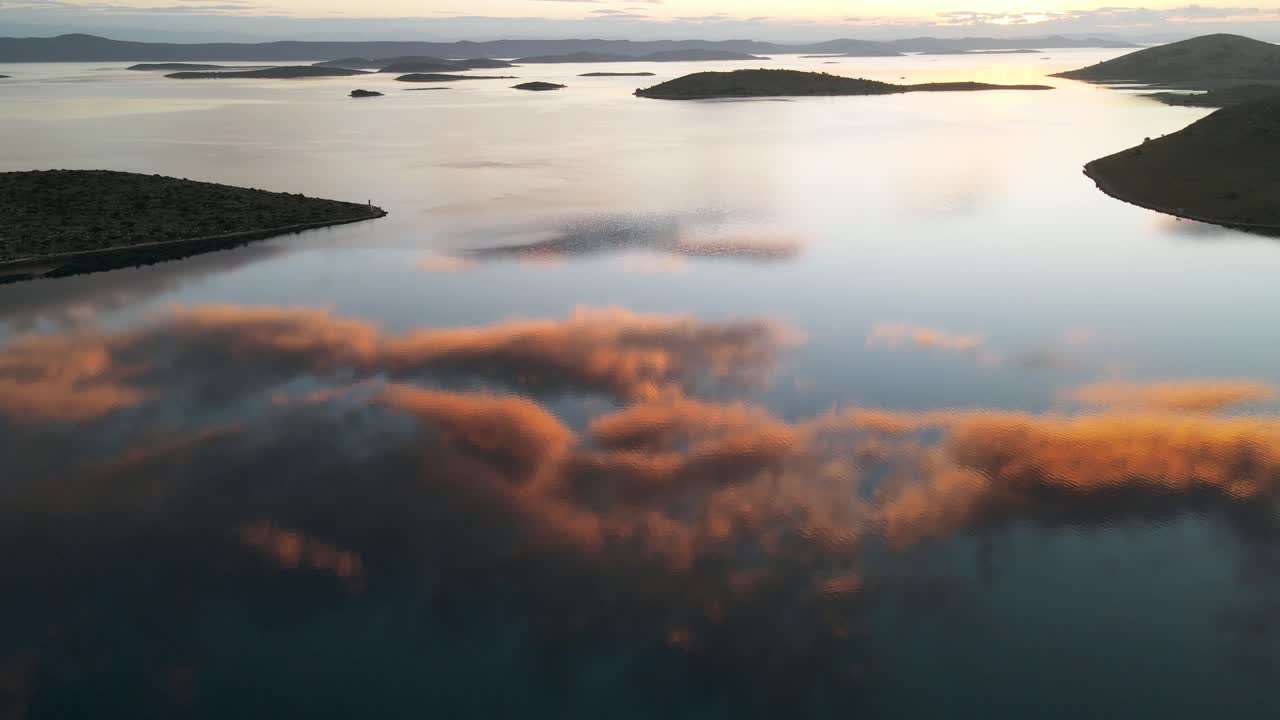 Kornati Milli Parkı'nda, durgun deniz suyunda yansıyan görkemli bulutlarla denizin üzerinde güzel gün batımı