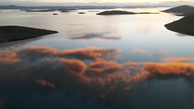 Bellissimo tramonto sul mare con il riflesso di nuvole maestose in acque marine tranquille, Parco Nazionale delle Kornati.