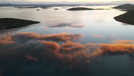 Hermosa-Puesta-De-Sol-Sobre-El-Mar-Con-Majestuosas-Nubes-Reflejadas-En-Tranquilas-Aguas-Marinas,-Parque-Nacional-Kornati