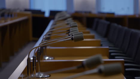 empty conference room with microphones lined up on desks