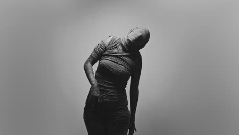 a mummified woman against the bright background moves erratically