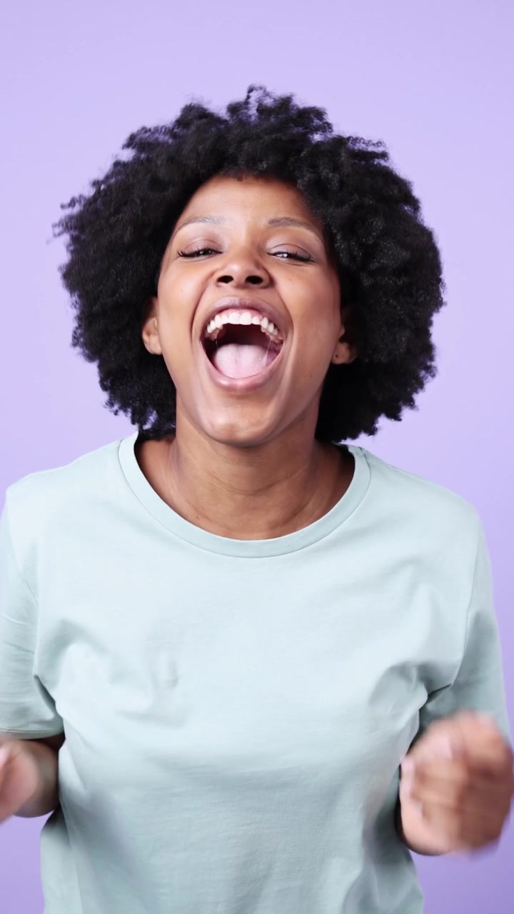Excited Young Black Woman with Afro Hair Reacting with Joy