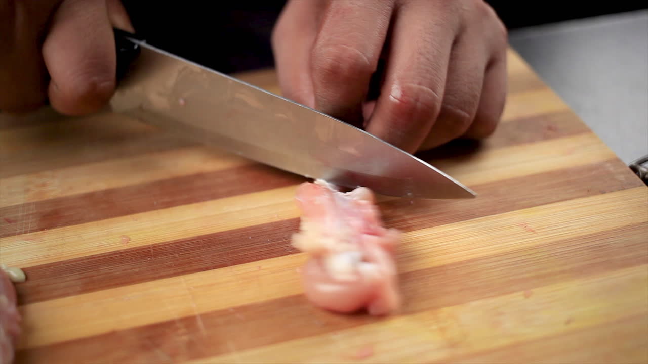 맛있는 인도 음식을 준비하기 위해 롤리팝 모양을 가져오기 위해 요리사가 칼로 자른 신선한 닭 날개