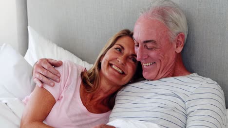 Senior-couple-embracing-on-bed