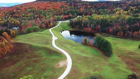 drone aerial view of countryside ranch with vivid multicolored forest on autumn