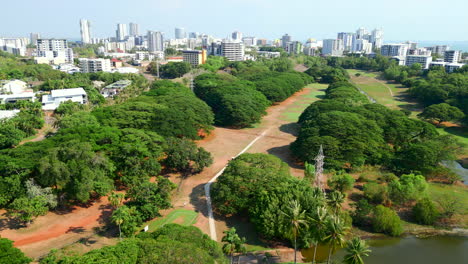 golf cart driving on the fairway of a beautiful city side golf course aerial drone