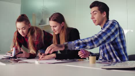 meeting of interior designer team in creative office. young hipster people making sketches sitting at the table and preparing their new project. slowmotion shot