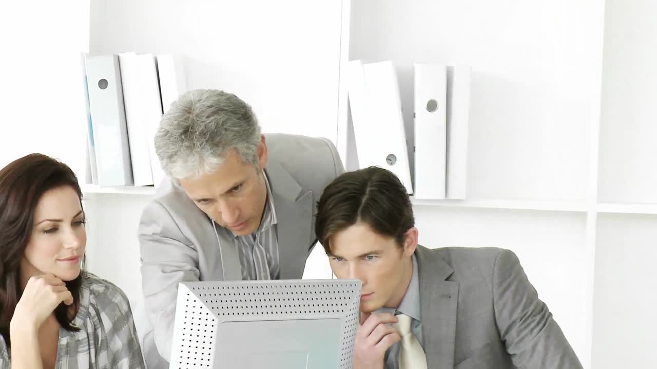 grupo de negocios positivo trabajando en una computadora