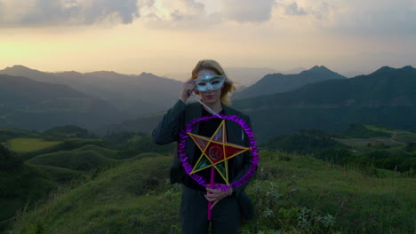 Slow-motion-shot-of-a-woman-putting-on-a-mask-and-holding-a-star-lantern