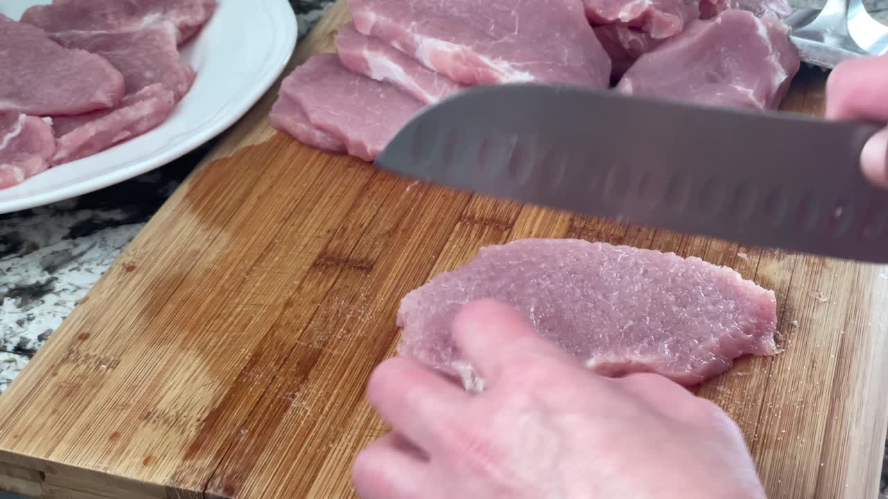 요리사의 칼로 생 돼지고기 조각에서 흰 지방을 잘라내는 것 - 부엌에 있는 나무 도마에 있는 고기 조각에서 단단한 지방을 잘라내는 것 - 집에서 지방을 자르는 것 - 슈니첼 레시피