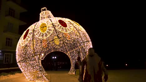 giant christmas ornament with santa claus in a snowy city
