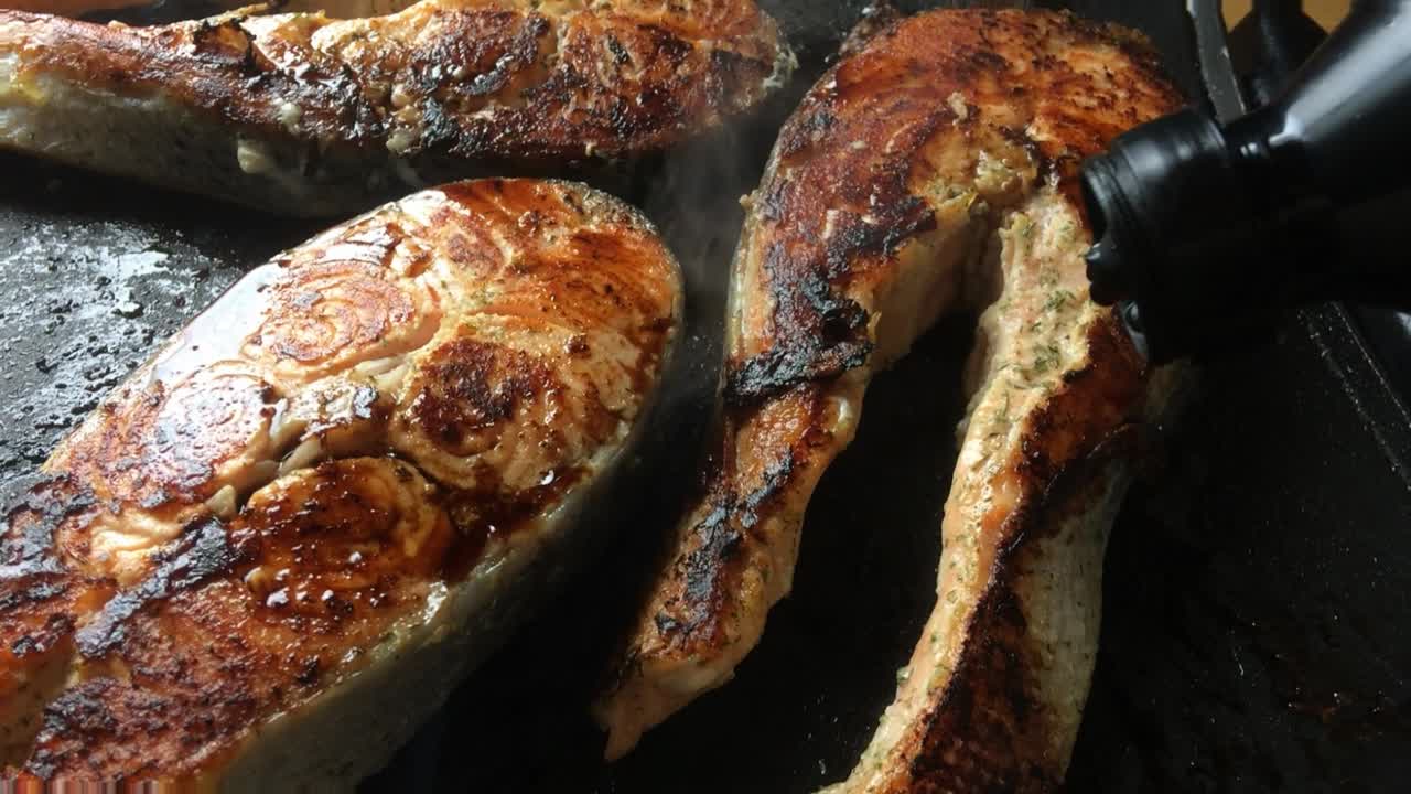 la fuente de soja natural se deja caer sobre filetes de salmón fresco mientras se asa en una parrilla eléctrica interior fácil de limpiar