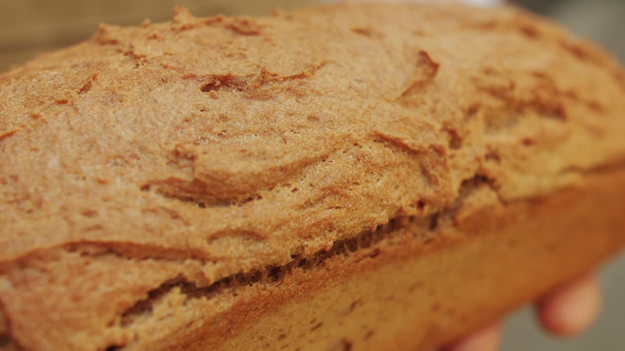The baker holds in hands a of fresh bread close-up. Artisan bread is making by skill bakers using natural and high-quality ingredients. Food with health and flavour benefits.