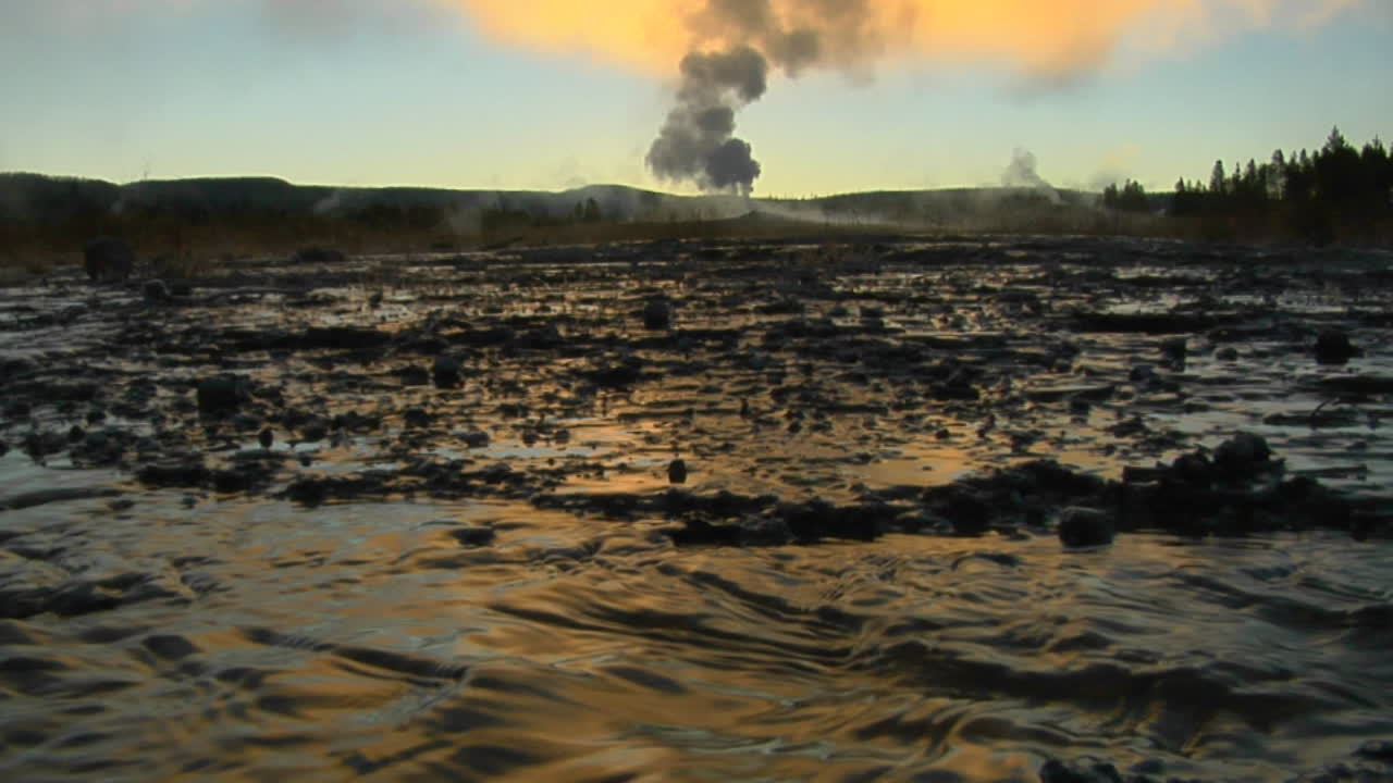el agua caliente sale de un géiser volcánico que envía vapor al cielo en un área geotérmica en el parque nacional de yellowstone