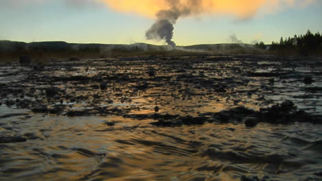 el agua caliente sale de un géiser volcánico que envía vapor al cielo en un área geotérmica en el parque nacional de yellowstone