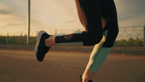 athletic-woman-is-running-outside-in-sunset-or-evening-close-up-of-body-dressed-in-sportswear