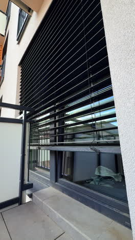sleek modern building with blinds. a contemporary building showcases a wall of large windows with horizontal black blinds, enhancing privacy and style