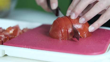 slicing tomatoes on pink board