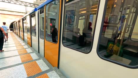 passengers enter train at naples subway station