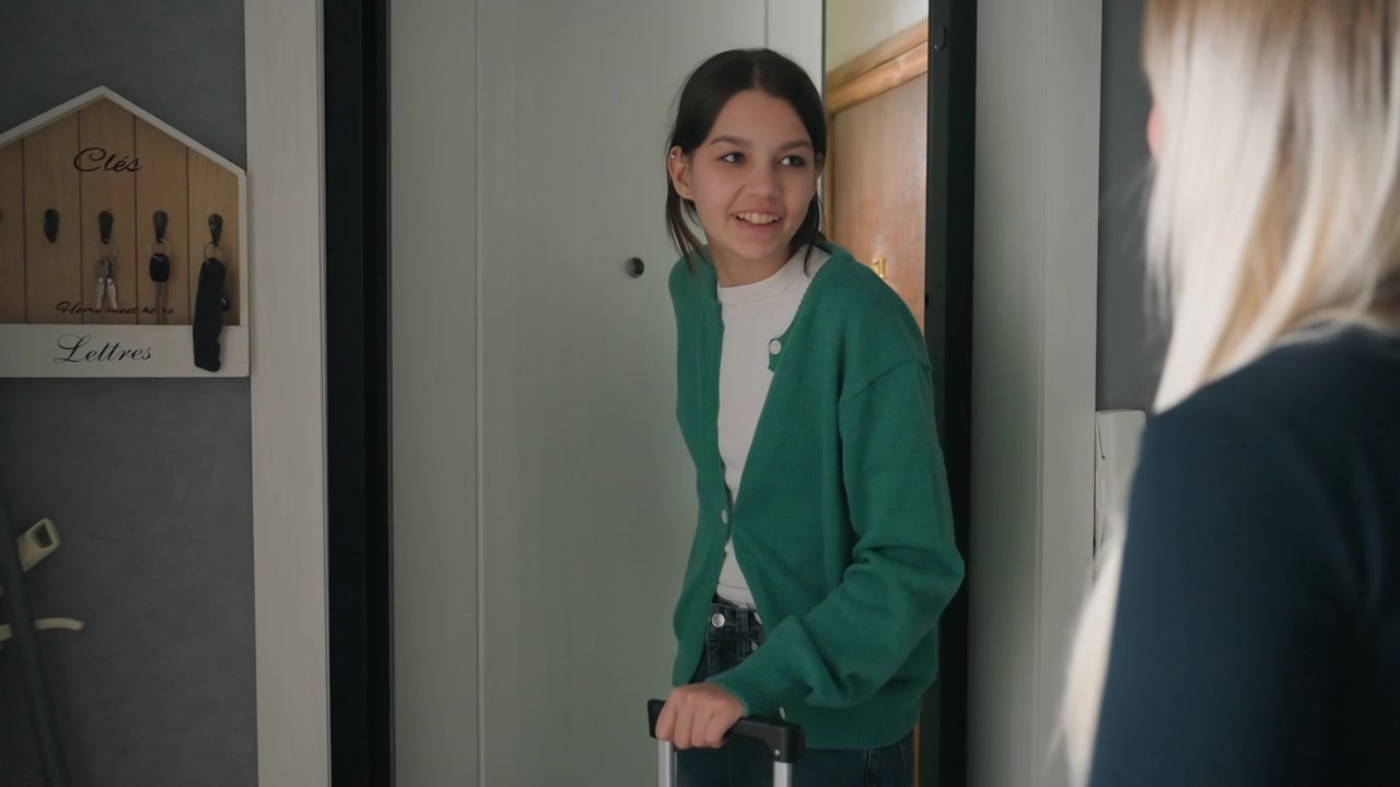 Friendly greeting in inviting entrance hallway. Woman welcomes guest bearing lush potted green plant. Charming scene of woman opening door to friend with thoughtful gift of greenery
