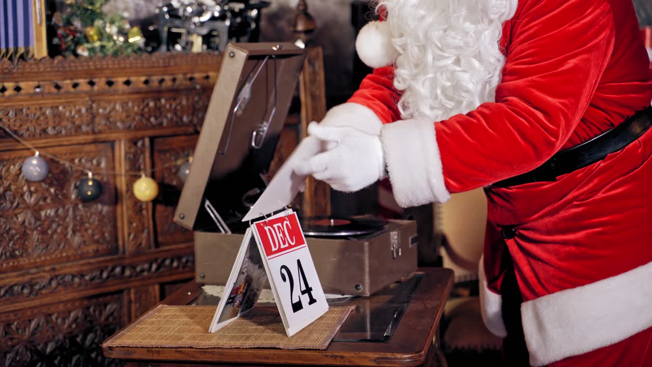 Santa Claus is turning a calendar page. Close up of Santa Claus with calendar. Feast is coming.Christmas eve video.