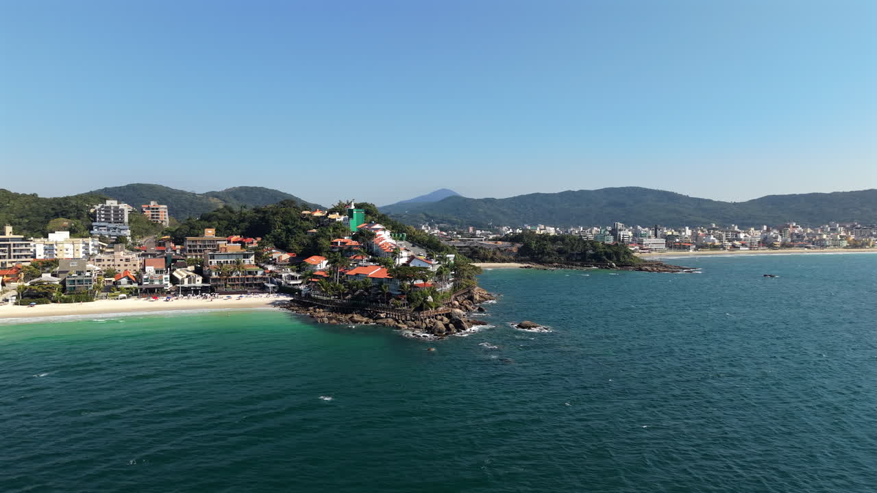 Aerial view of Praia Bombinhas beach, blue sea and rocky coast, Brazil