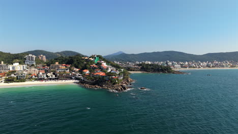 aerial view of praia bombinhas beach, blue sea and rocky coast, brazil